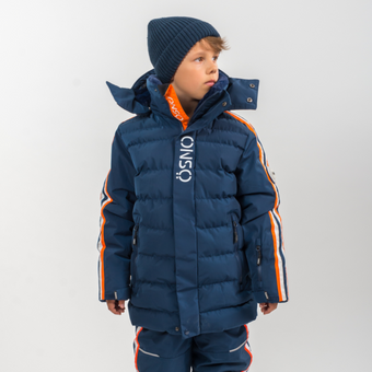 Child wearing a blue winter coat with orange and white accents on a light gray background