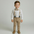 Young boy wearing a formal outfit with suspenders and a bow tie on a plain background